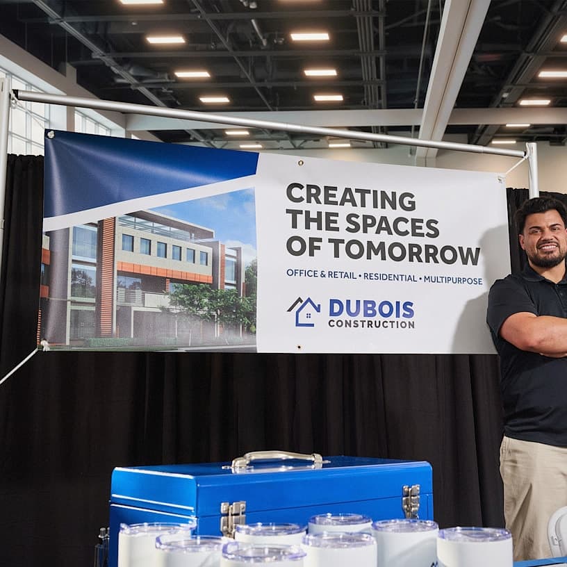 Voqado Vinyl banners: A vinyl banner promoting a construction company hanging up at a trade show.; printed design examples, styling props not included.